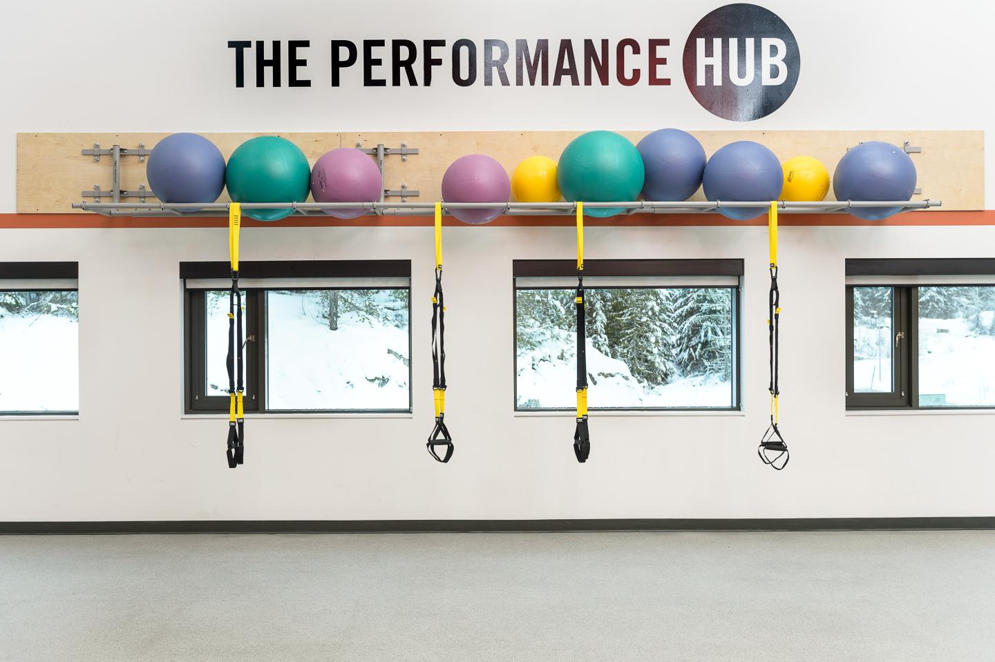 a wall with yoga balls and exercise straps with a The Hub logo decal