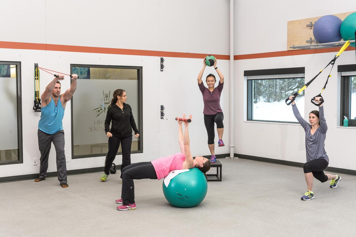 people in fitness room using various pieces of equipment