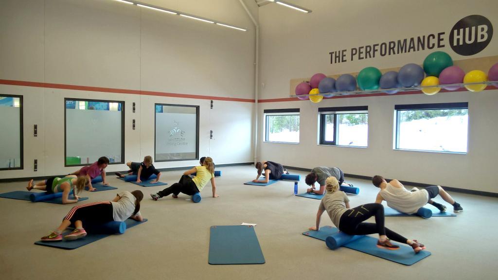 people laying on exercise mats, participating in an exercise class