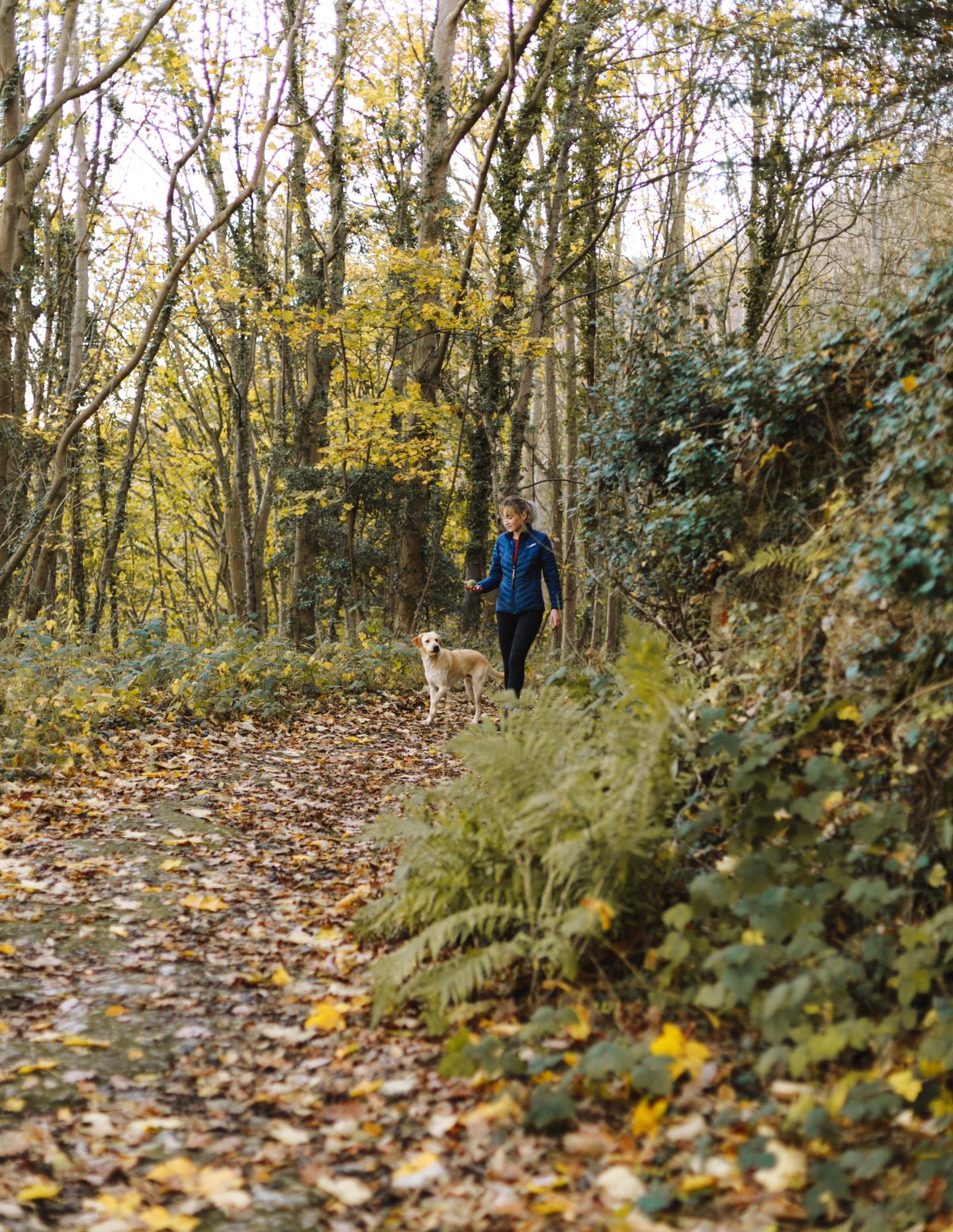 woman walking on trail with dog